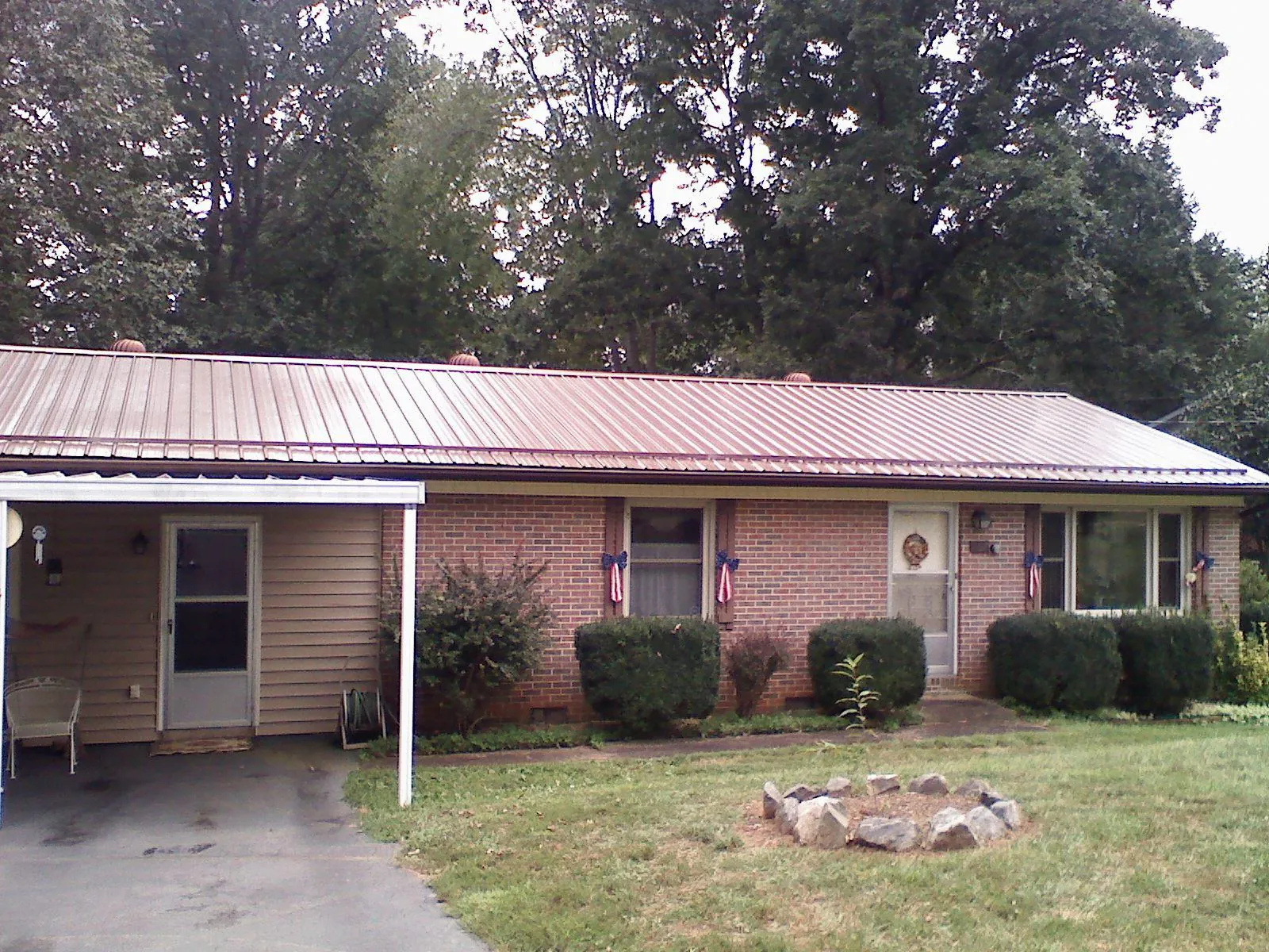 Bronze metal roof and carport on a brick ranch home — Roof Repair work by our crew in Milroy
